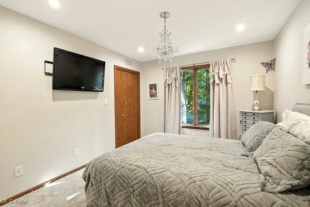 Bedroom featuring carpet, recessed lighting, and a chandelier