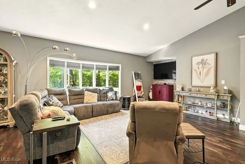 Living room featuring wood finished floors, lofted ceiling, a ceiling fan, and recessed lighting