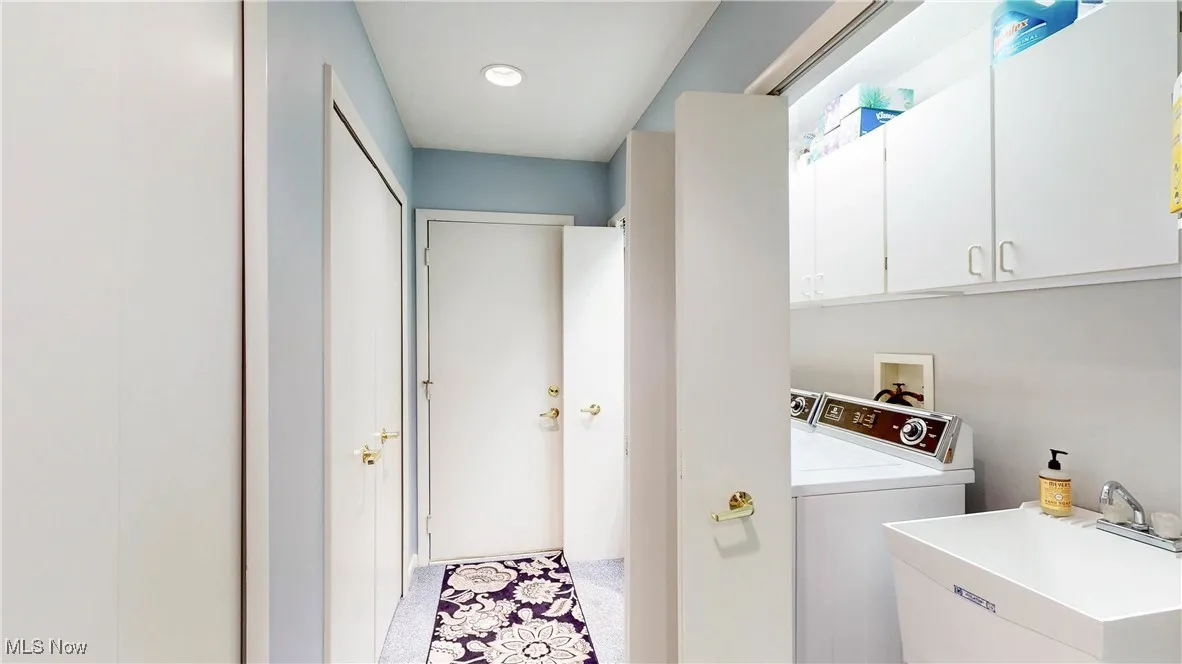 Laundry area featuring independent washer and dryer and cabinet space
