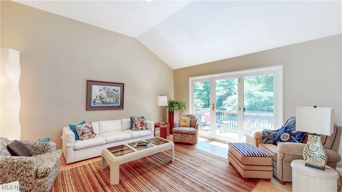 Living room with lofted ceiling and light wood finished floors