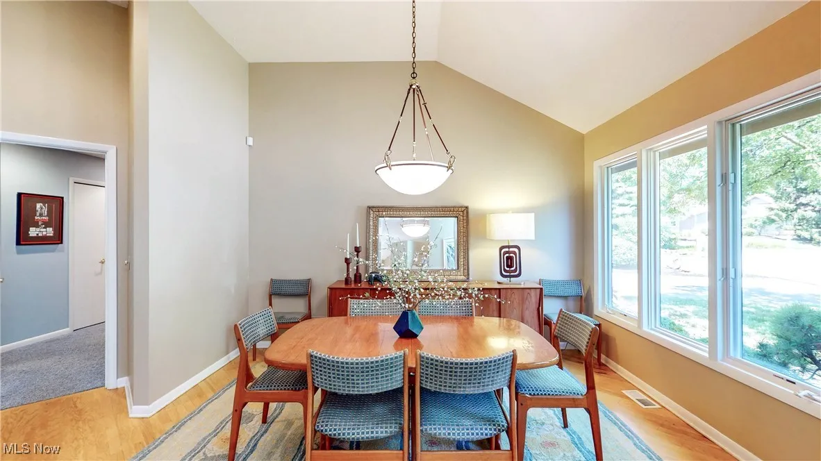 Dining area featuring light wood-type flooring and high vaulted ceiling