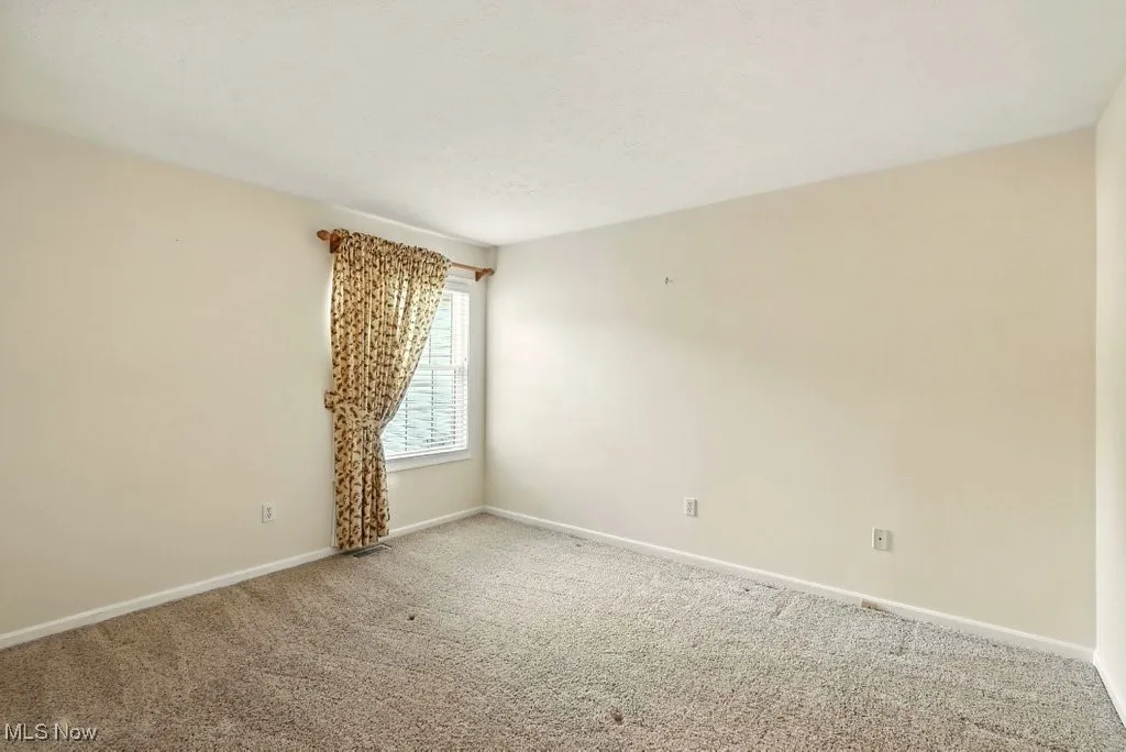 Unfurnished room featuring baseboards and carpet floors