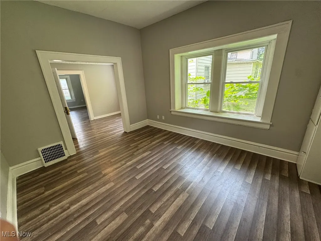 Formal dining room with baseboards and dark wood-style floors