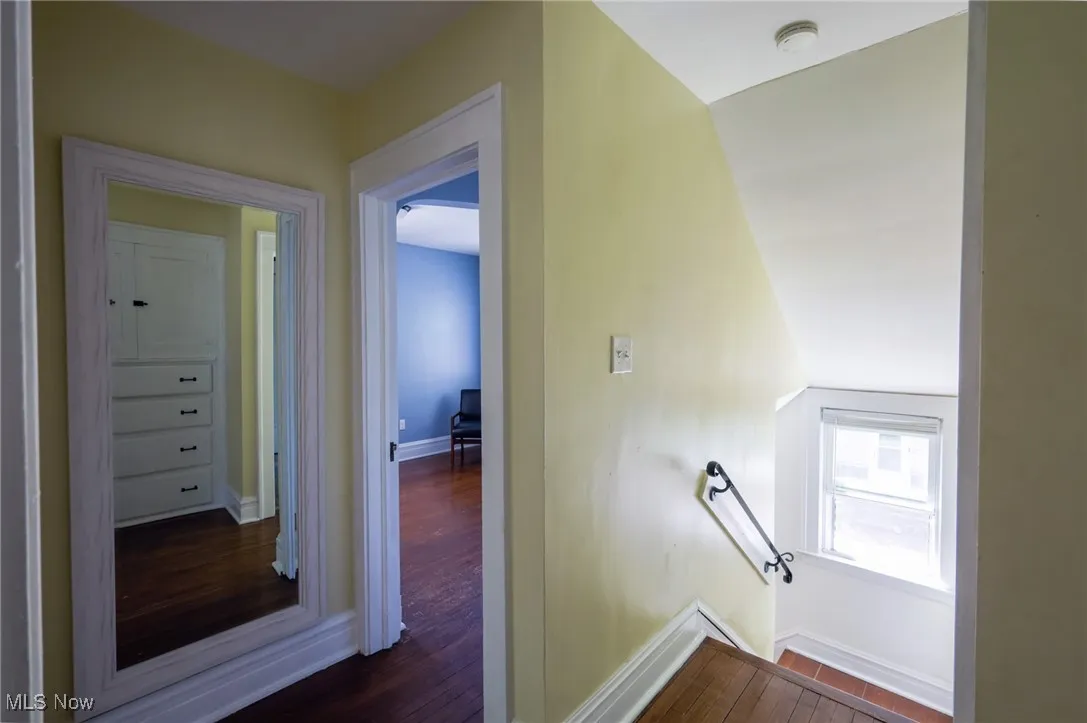 Hall featuring wood finished floors and an upstairs landing