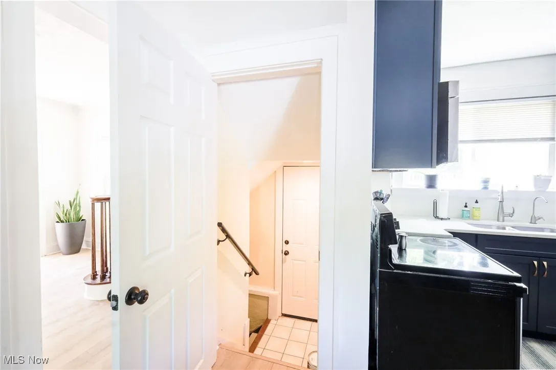 Kitchen featuring black / electric stove, light countertops, and blue cabinets