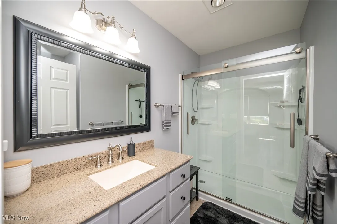 Primary Bedroom Suite Features this fantastic recently updated full bathroom. Note the gorgeous granite countertop and step-in shower with glass doors!