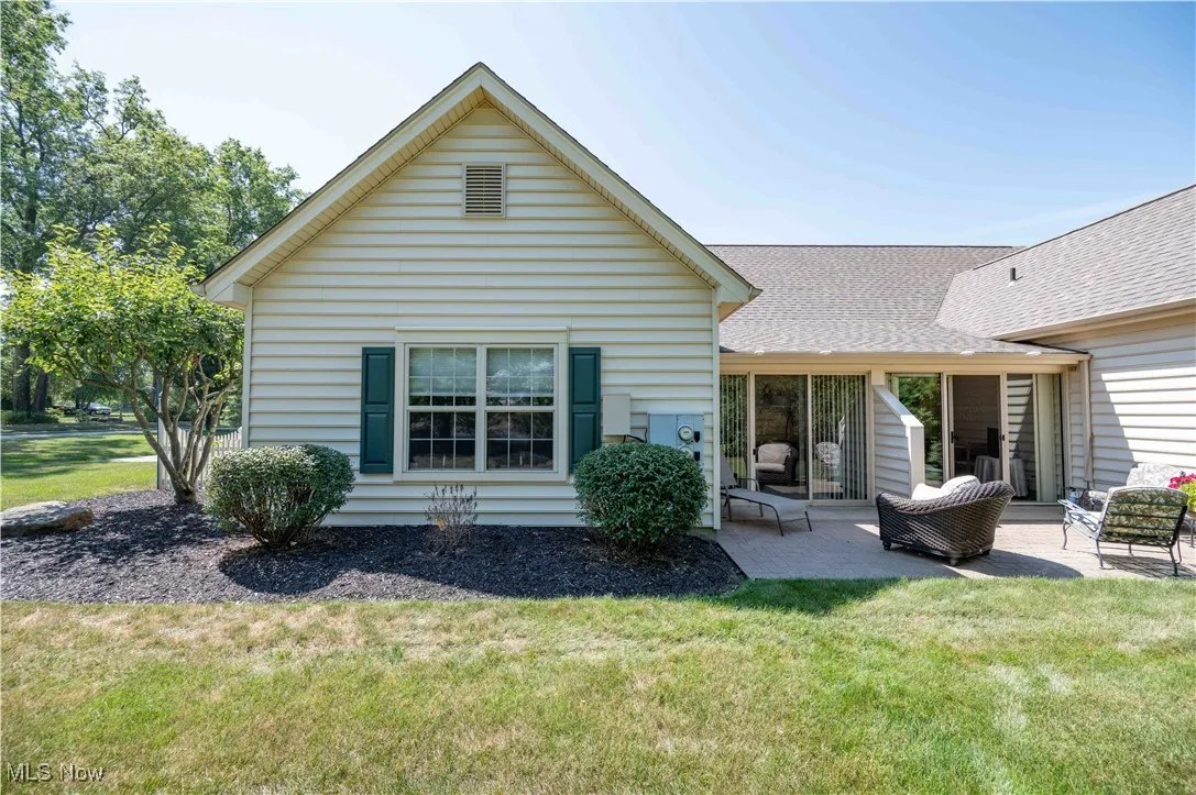 Rear view of property with a patio area and landscaping.