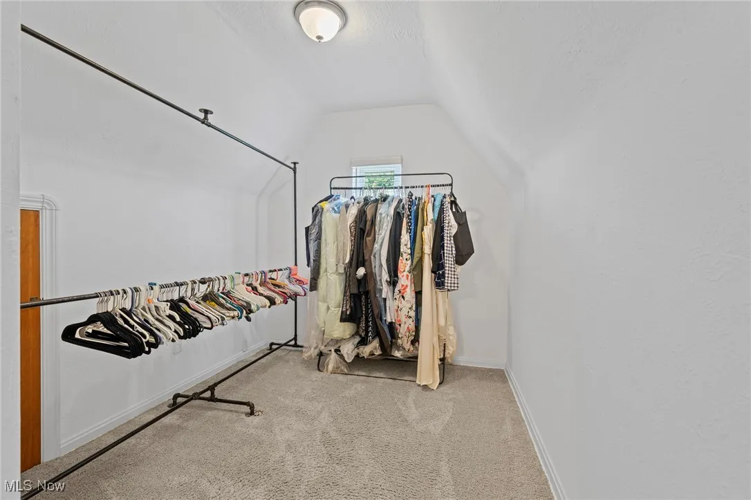 Spacious closet with lofted ceiling and carpet floors