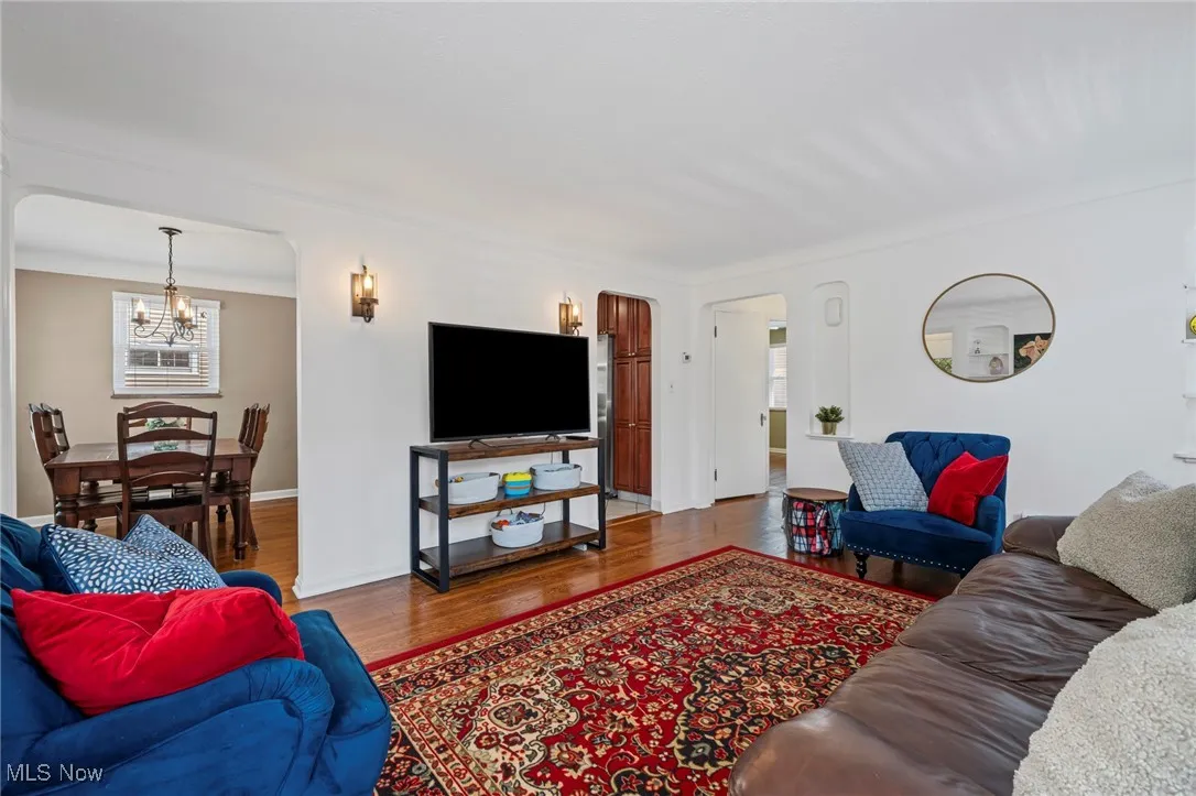 Living room featuring a chandelier, wood finished floors, and arched walkways
