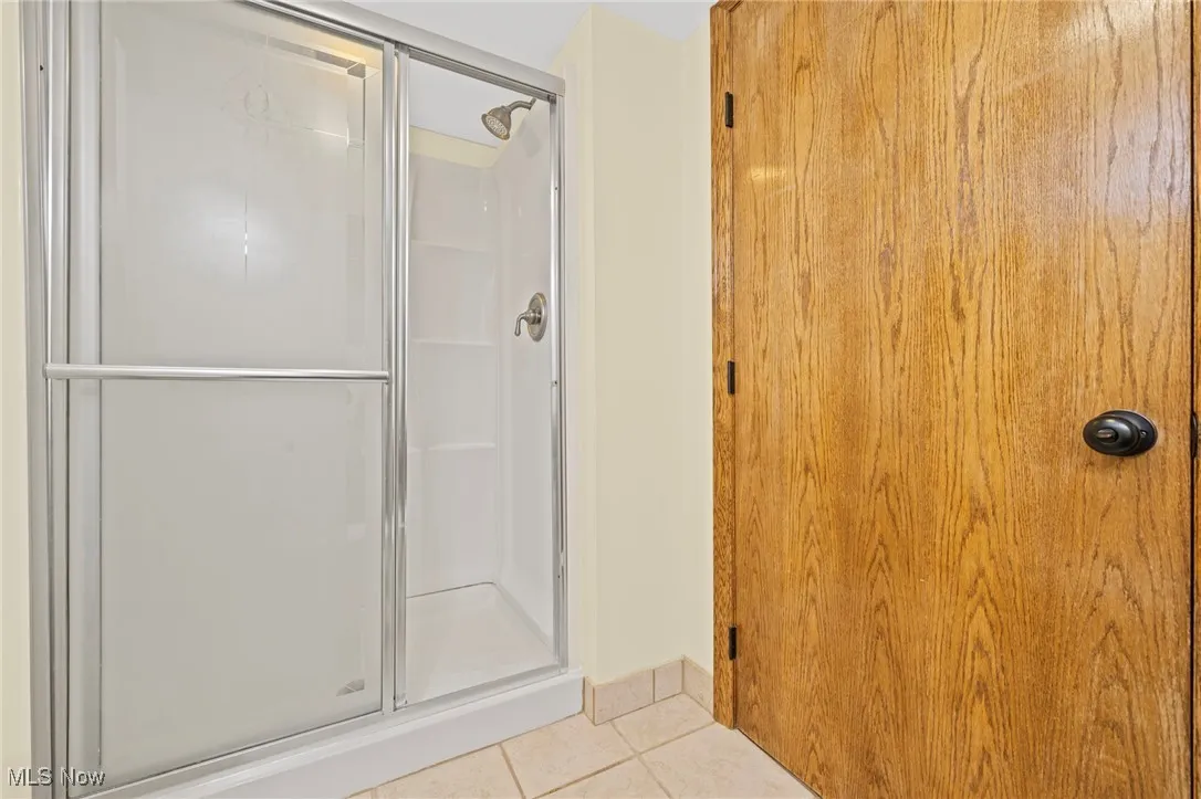 Full bathroom with a stall shower and tile patterned floors