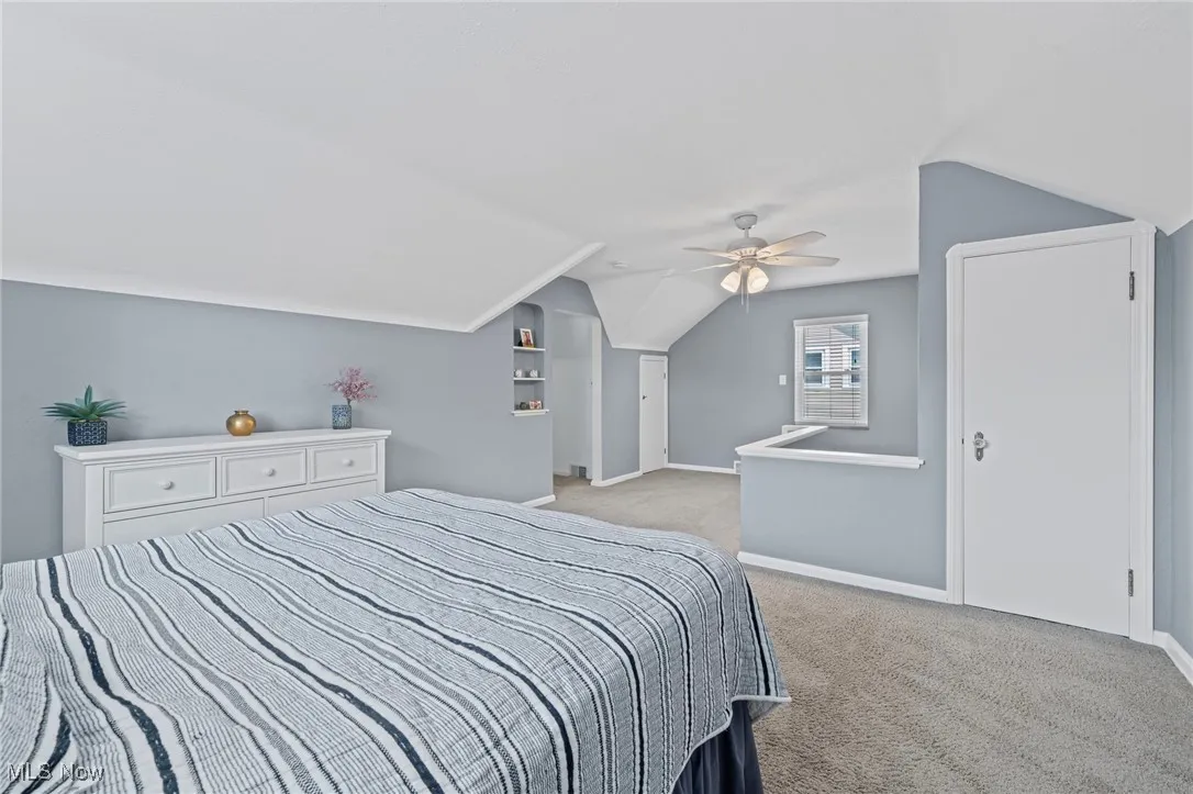 Bedroom with carpet floors, vaulted ceiling, and ceiling fan