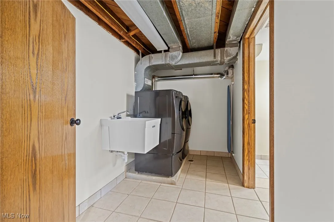 Laundry area with light tile patterned floors and baseboards