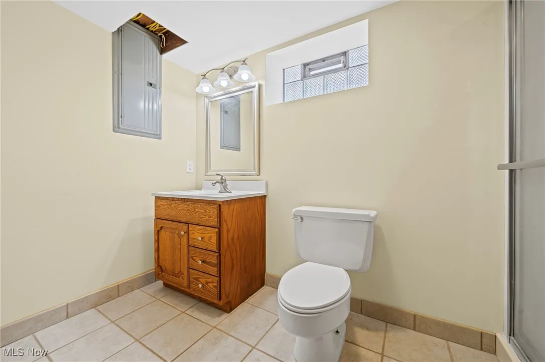 Bathroom with vanity, electric panel, and tile patterned floors