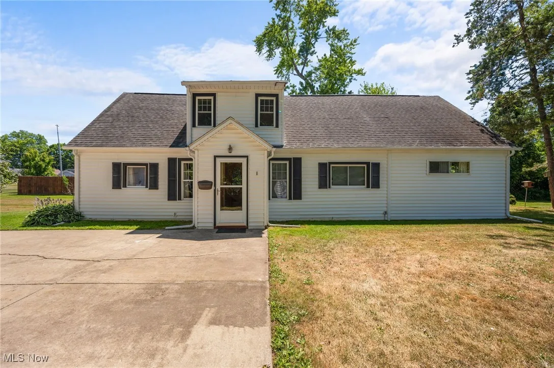 View of front of house with roof with shingles and a front lawn