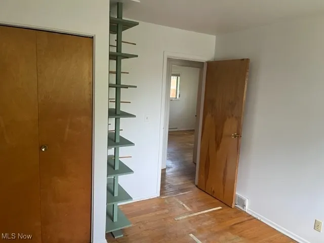Corridor featuring wood finished floors and baseboards