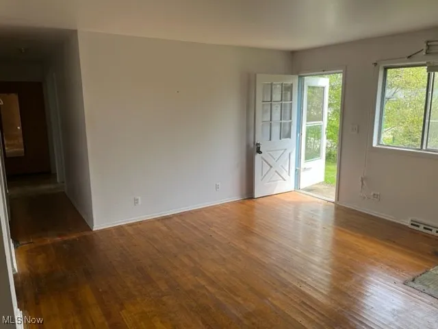 Empty room featuring hardwood / wood-style flooring and baseboards