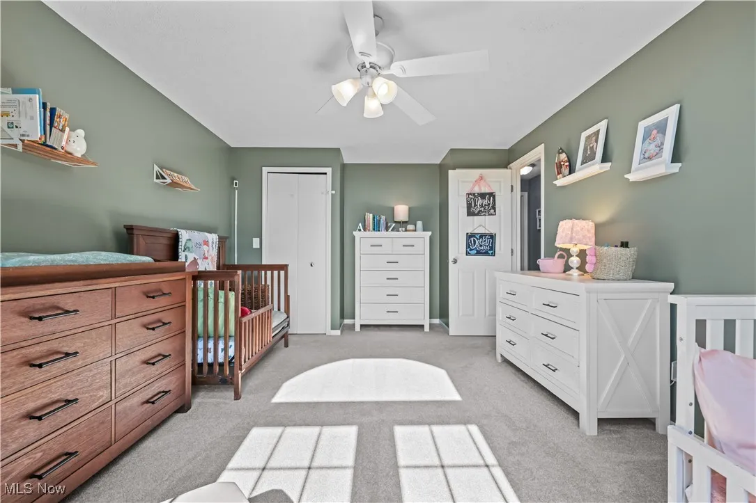 Bedroom featuring light carpet, a closet, and ceiling fan