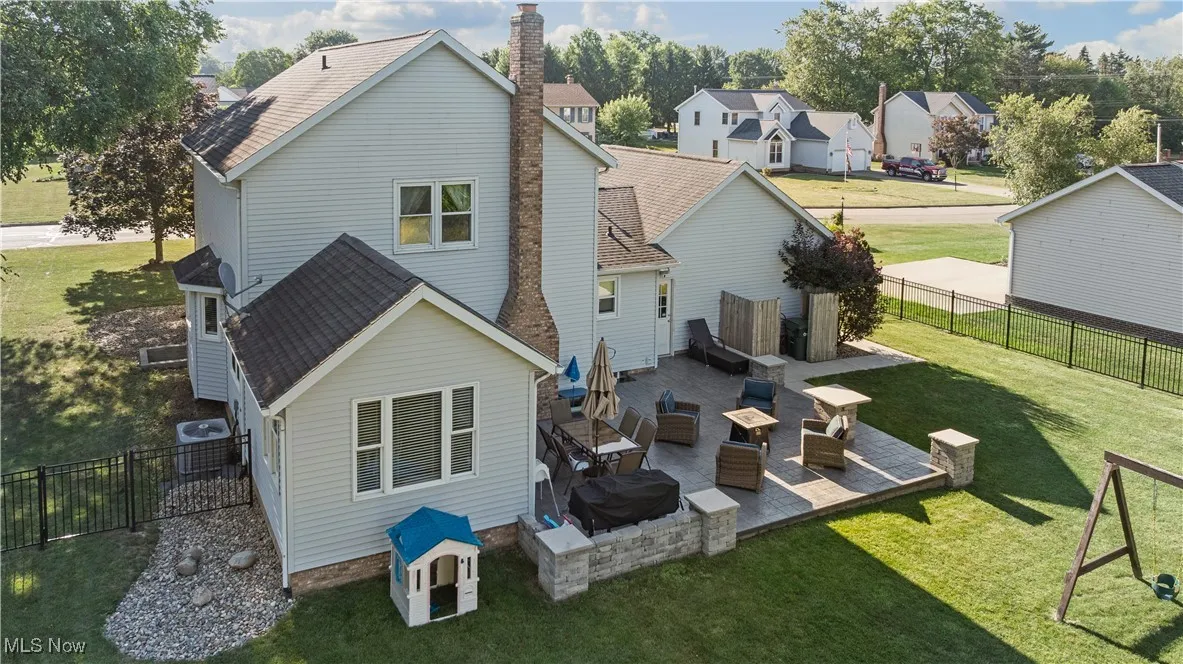 Back of property with a residential view, a patio area, roof with shingles, and a fenced backyard