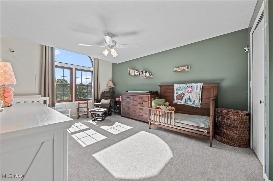 Bedroom with light carpet and ceiling fan