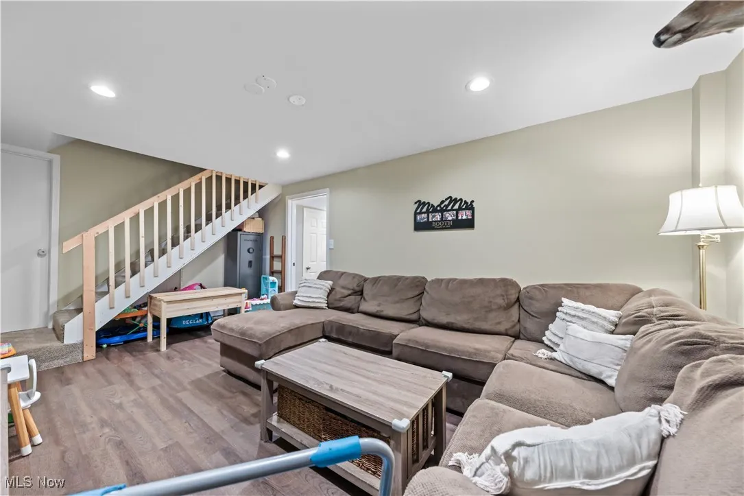 Living room featuring wood finished floors, stairway, and recessed lighting