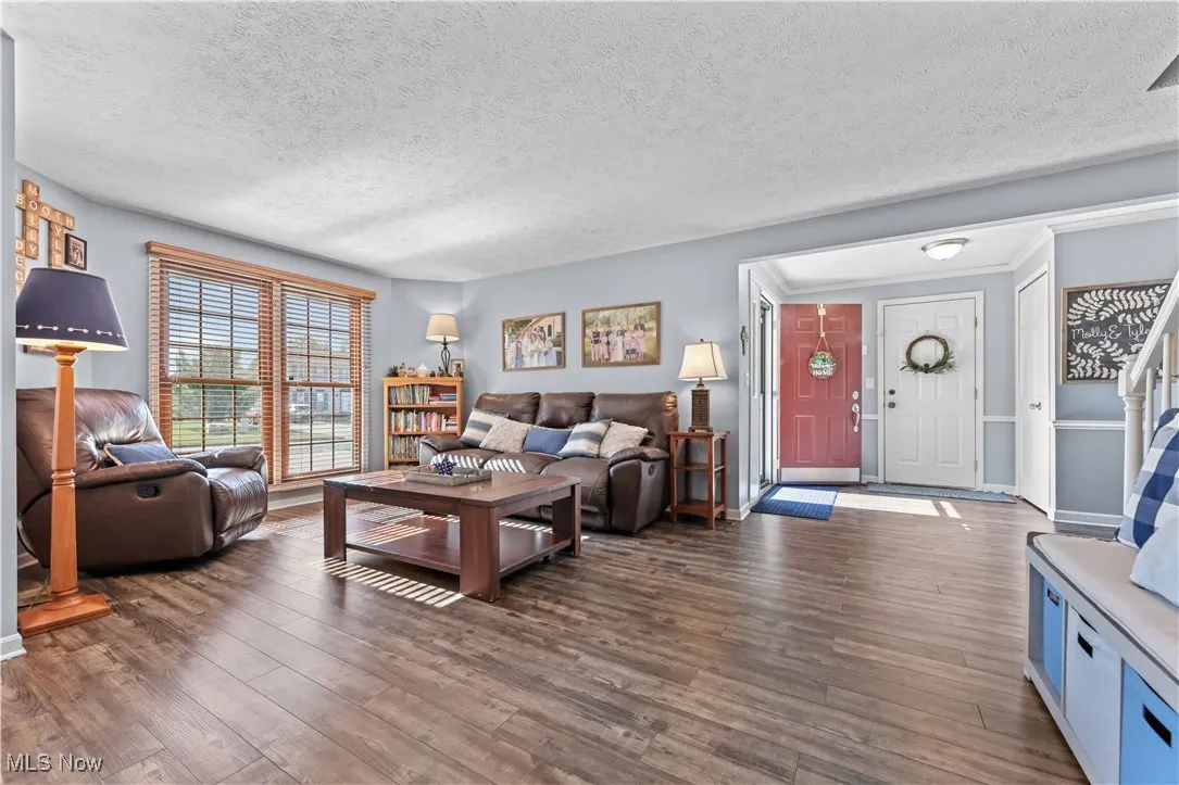 Living room featuring a textured ceiling and dark wood finished floors