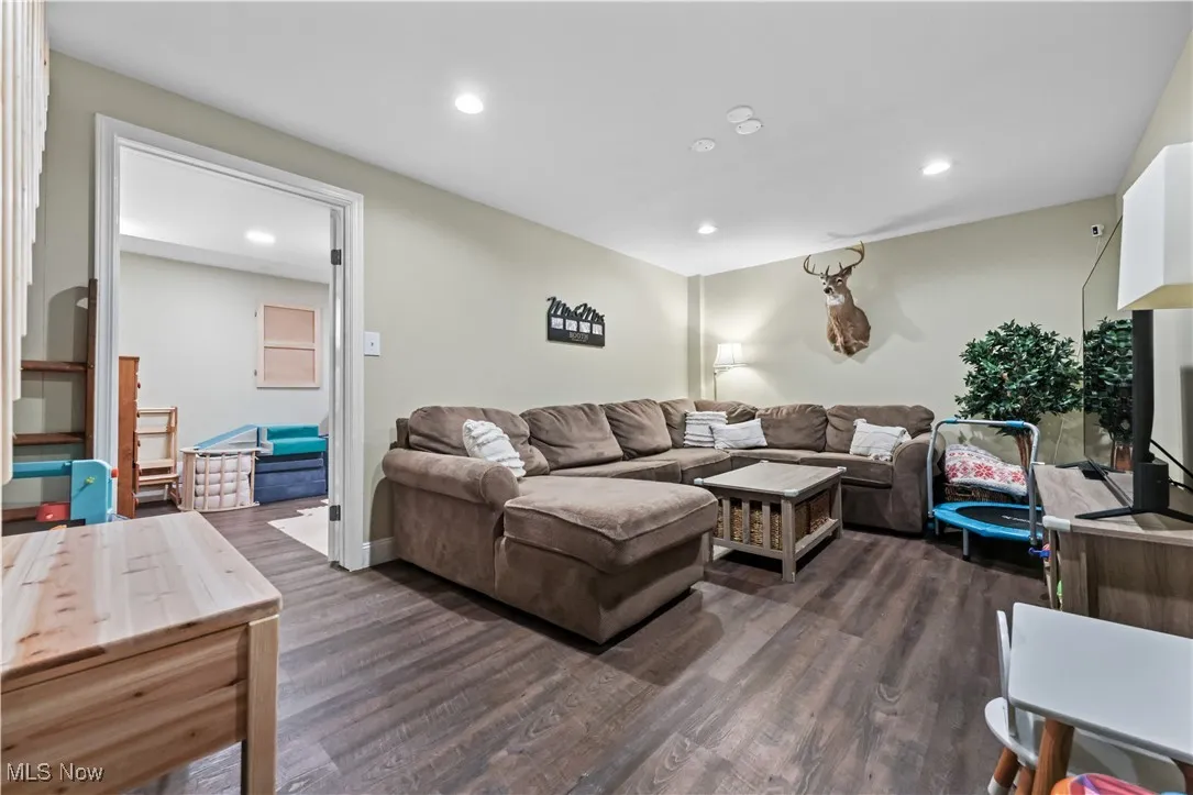Living room with dark wood-style floors and recessed lighting