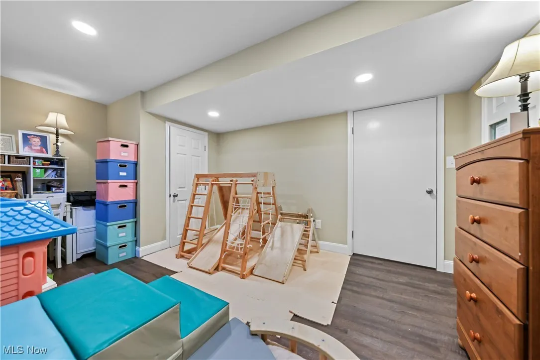 Recreation room with wood finished floors and recessed lighting