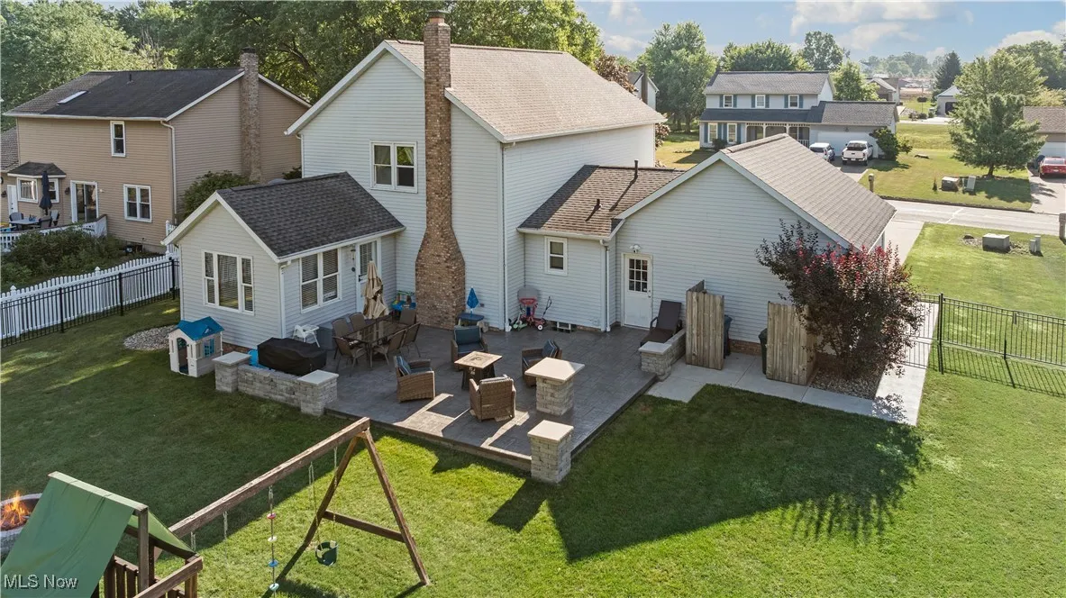 Back of house featuring a residential view, roof with shingles, a patio area, and a fenced backyard
