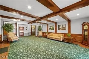 Common area featuring beamed ceiling, wainscoting, and coffered ceiling