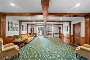 Lobby featuring a wainscoted wall, beamed ceiling, recessed lighting, and wood walls