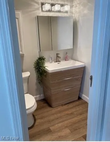 Half bath featuring vanity and wood finished floors
