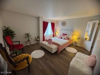 Bedroom featuring wood finished floors and baseboards