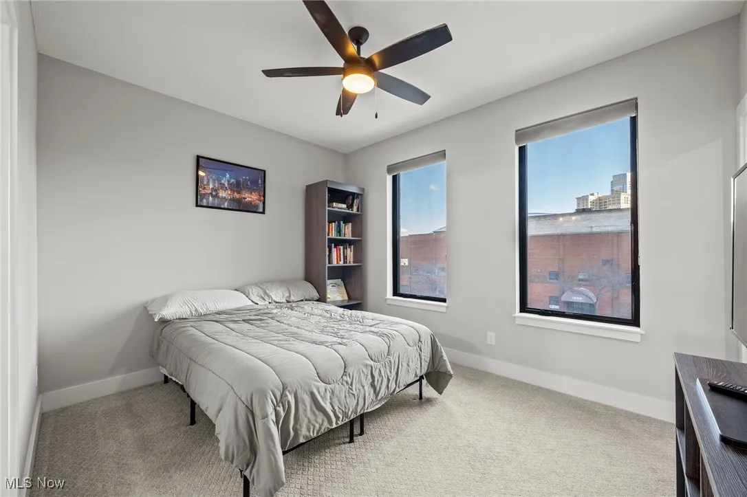 Carpeted bedroom featuring baseboards and ceiling fan