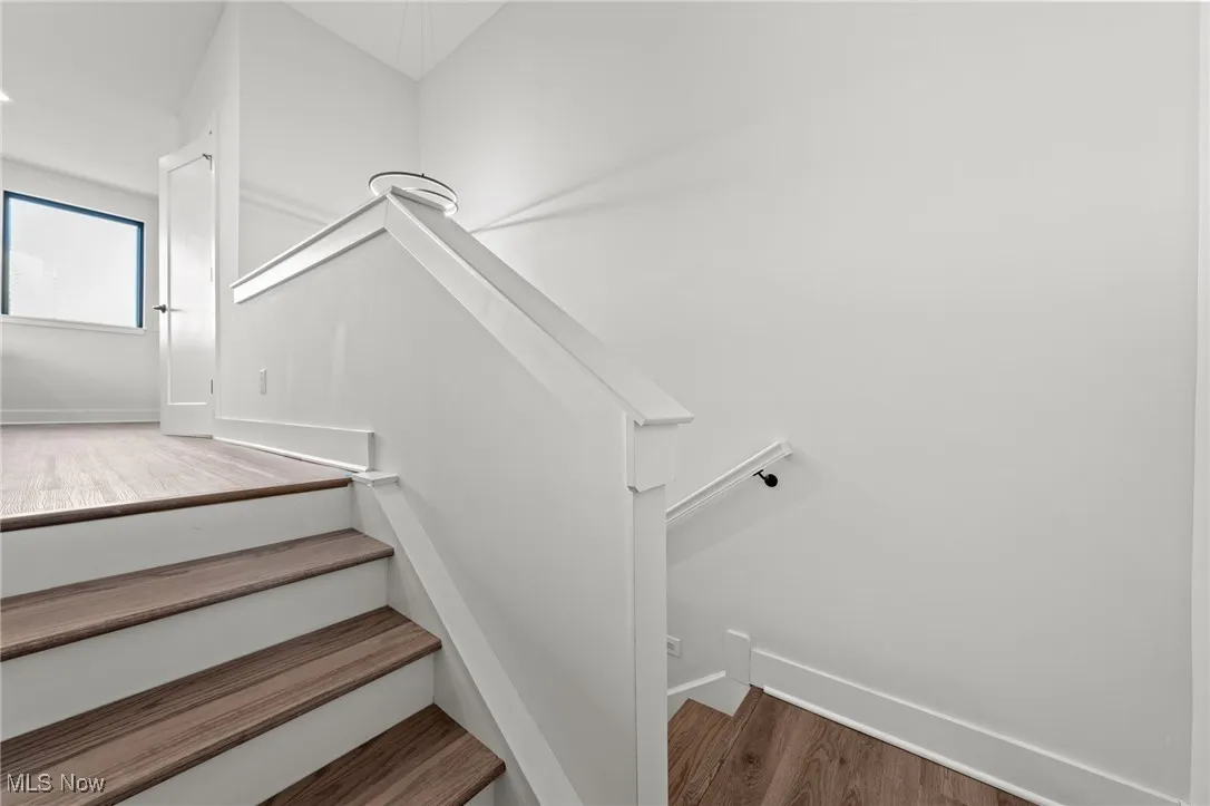 Stairway featuring wood finished floors and baseboards