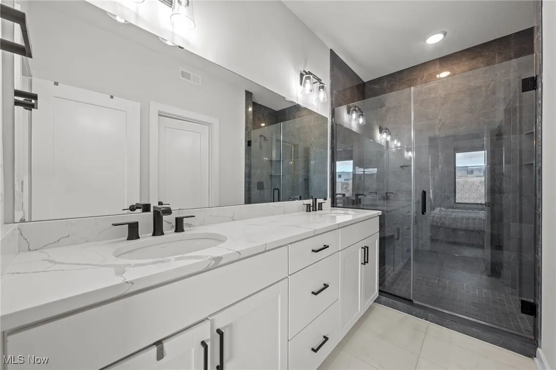 Bathroom with double vanity and a stall shower