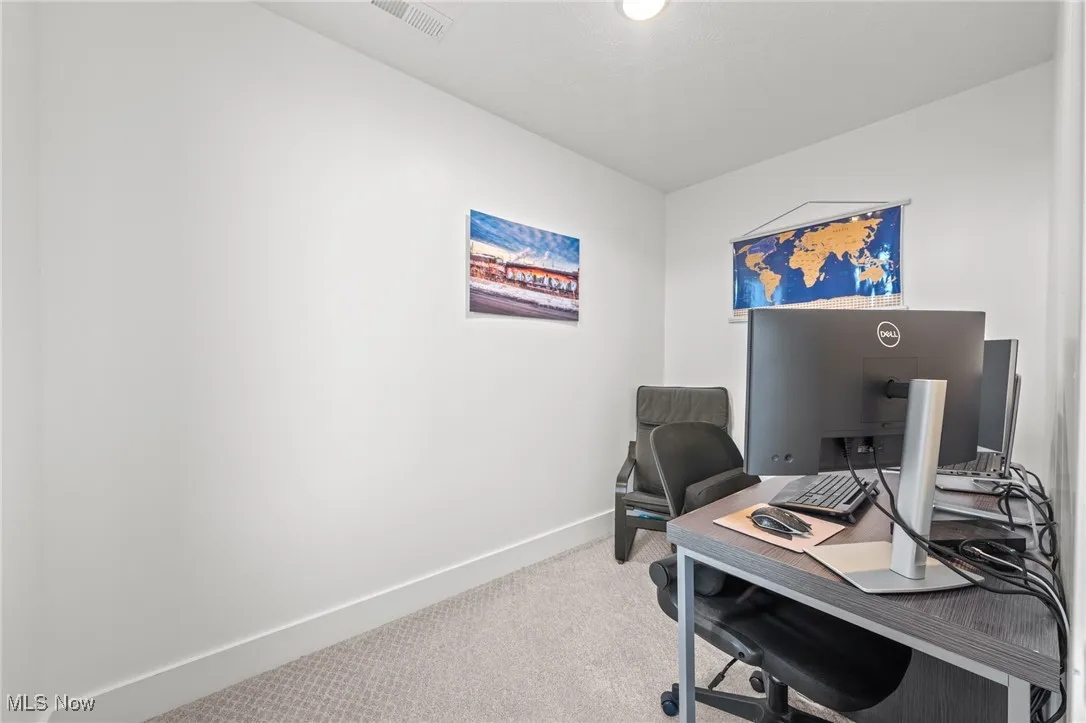 Carpeted office space with baseboards