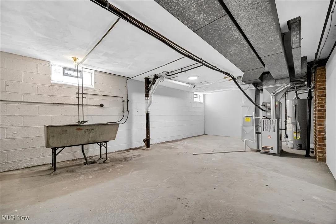 Basement featuring heating unit and water heater
