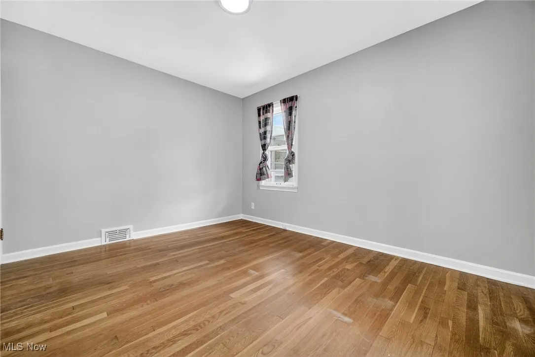 Spare room featuring wood finished floors and baseboards