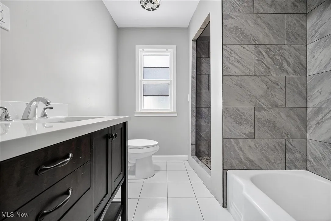 Bathroom with tile patterned floors and vanity