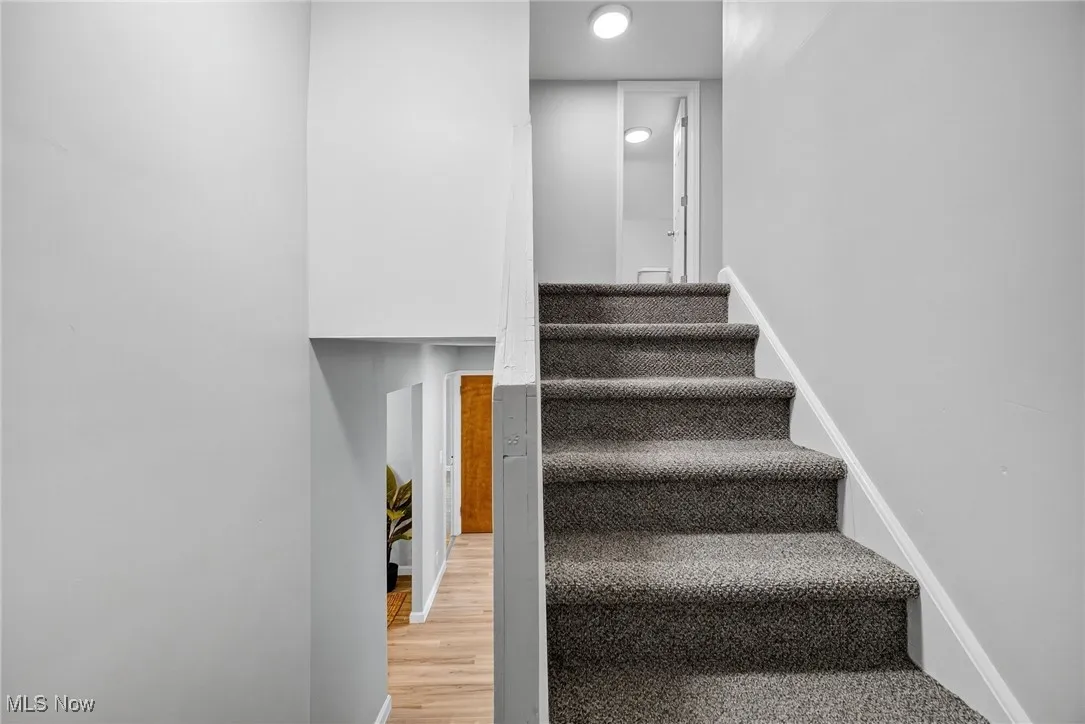Stairs with baseboards and wood finished floors