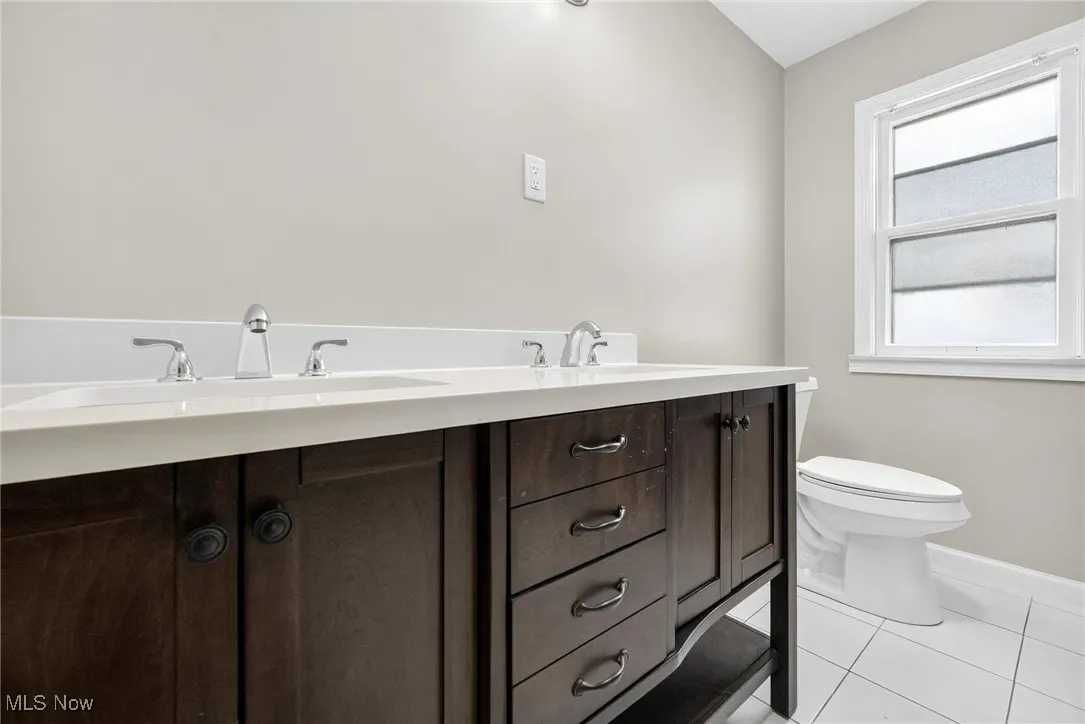 Bathroom featuring tile patterned flooring and double vanity