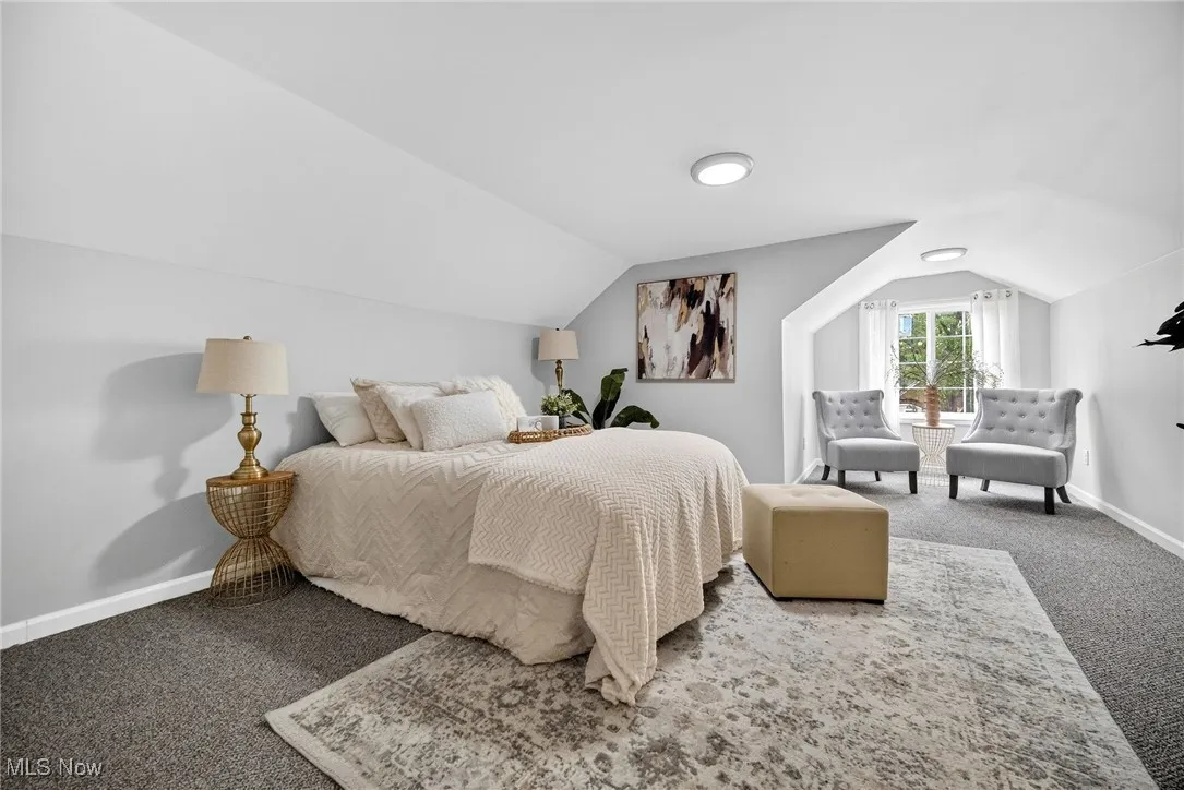 Carpeted bedroom featuring lofted ceiling and baseboards