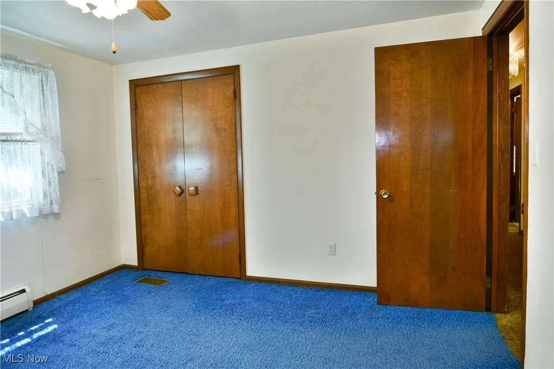 Unfurnished bedroom featuring carpet floors, a closet, and a ceiling fan