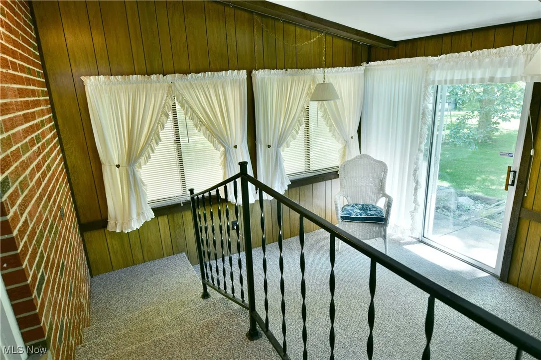 Stairway featuring wooden walls and carpet flooring