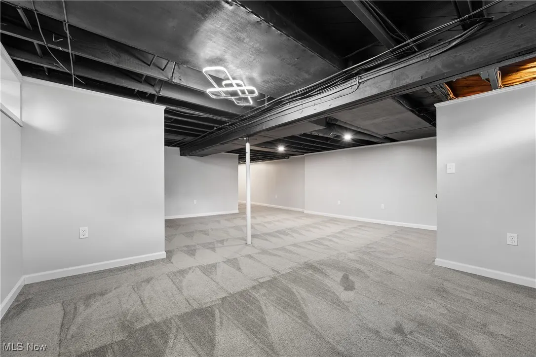 Finished below grade area featuring baseboards and carpet