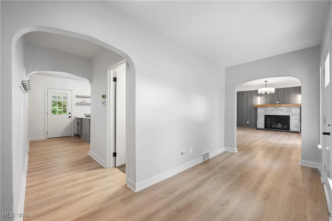 Hall with light wood-style flooring and arched walkways