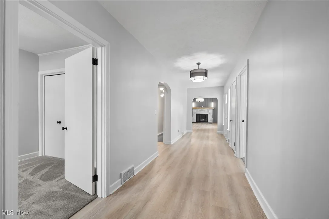 Corridor featuring light wood-style flooring and arched walkways