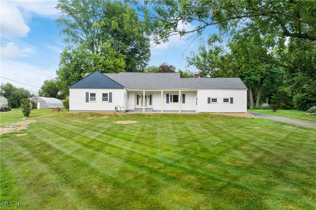 Ranch-style house featuring a front lawn and a chimney