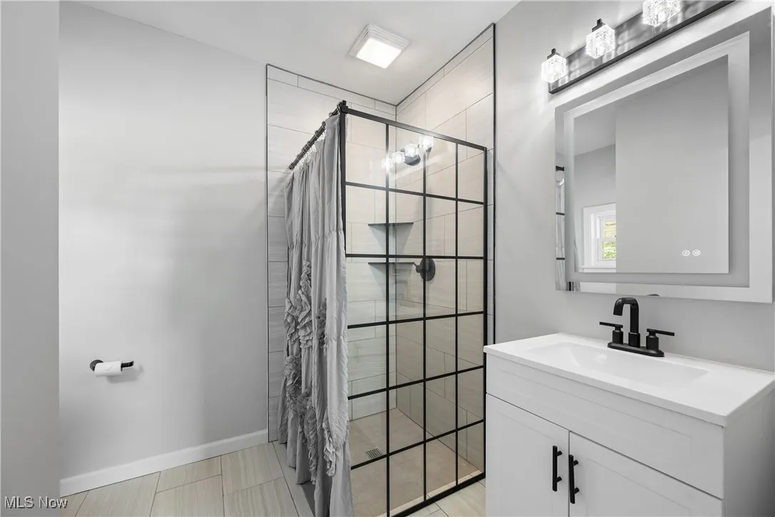 Full bath featuring a shower stall and vanity