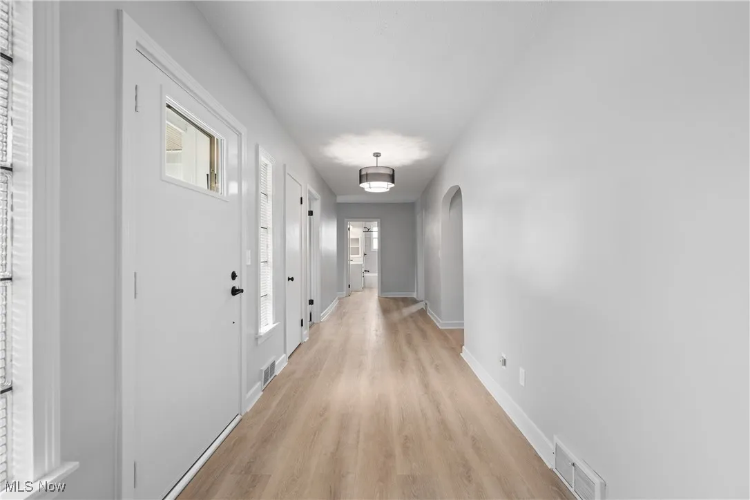 Hall with light wood-style floors and arched walkways
